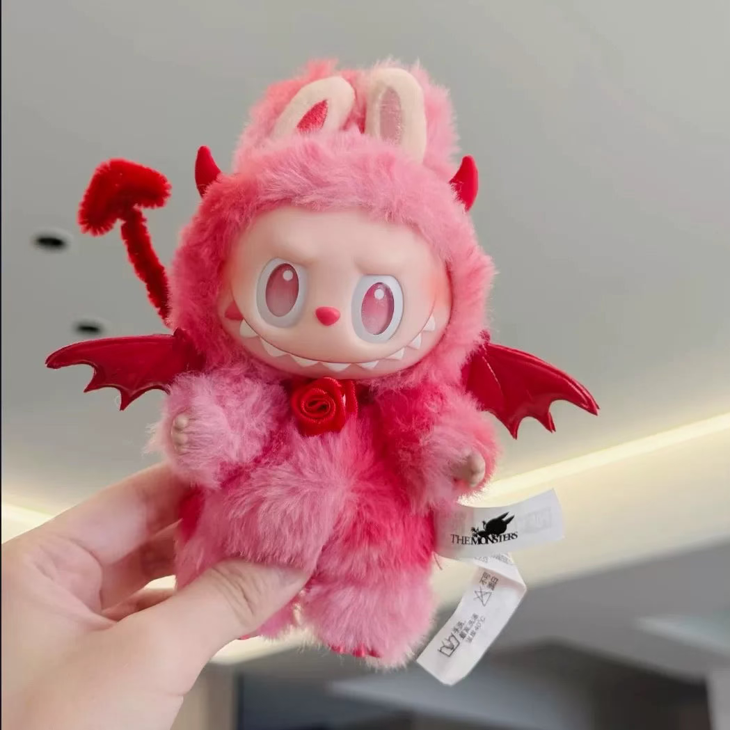 Monster Closet Labubu plush outfit with red devil horns and tail held by a hand against a neutral background